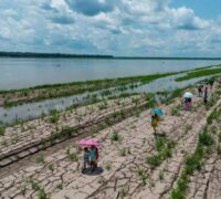 Människor går längs en del av Amazonfloden som visar tecken på torka i Santa Sofia, i utkanten av Leticia i Colombia.