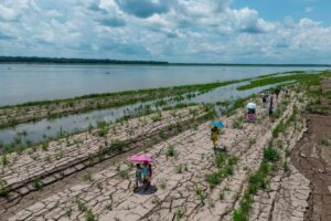 Människor går längs en del av Amazonfloden som visar tecken på torka i Santa Sofia, i utkanten av Leticia i Colombia.