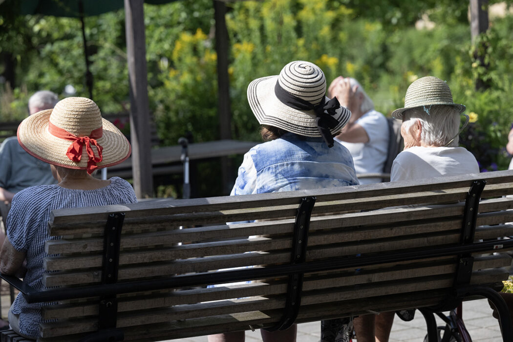 pensionärer i hatt på parkbänk
