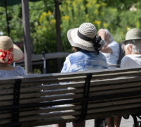 pensionärer i hatt på parkbänk