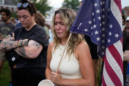 En demonstrant kämpar för att hålla tillbaka tårarna vid en demonstration mot ICE efter att en man skjutits ihjäl av den amerikanska immigrations- och tullmyndigheten (ICE) måndagen den 13 juli 2026 i Biddeford, Maine. (AP Photo/Robert F. Buka