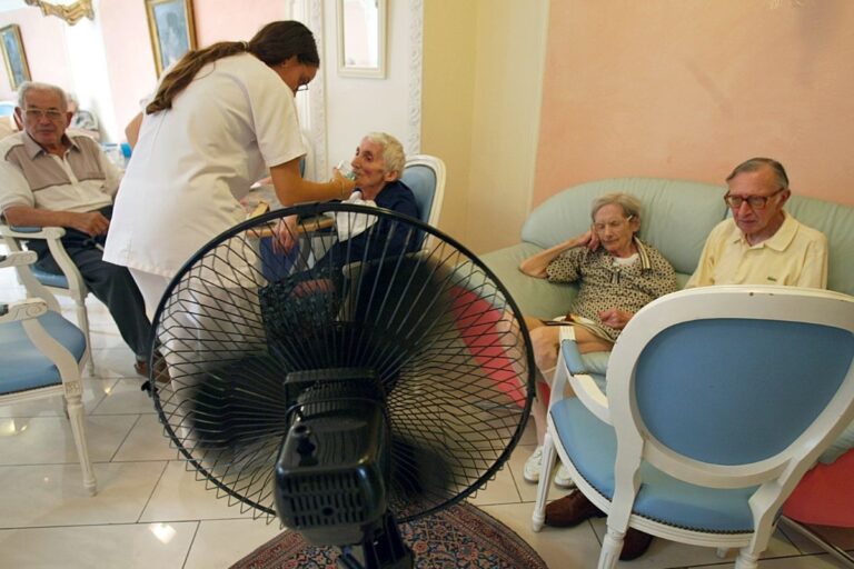 En sjuksköterska serverar drycker till pensionärer på ett äldreboende i Paris.