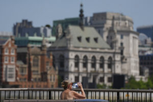 En kvinna dricker vatten under en varm dag i London. Storbritannien har den senaste tiden drabbats av flera värmeböljor, och enligt Met Office har landets klimat förändrats i grunden.