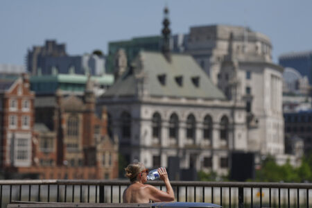 En kvinna dricker vatten under en varm dag i London. Storbritannien har den senaste tiden drabbats av flera värmeböljor, och enligt Met Office har landets klimat förändrats i grunden.