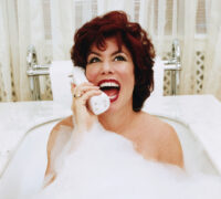Ruby Wax talar i en stor vit telefonlur i badet