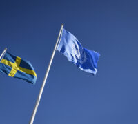 Sveriges flagga vajar intill FN-flaggam