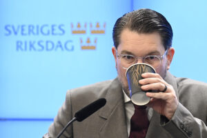 Åkesson i riksdagens pressrum, drickandes kaffe ur pappmugg