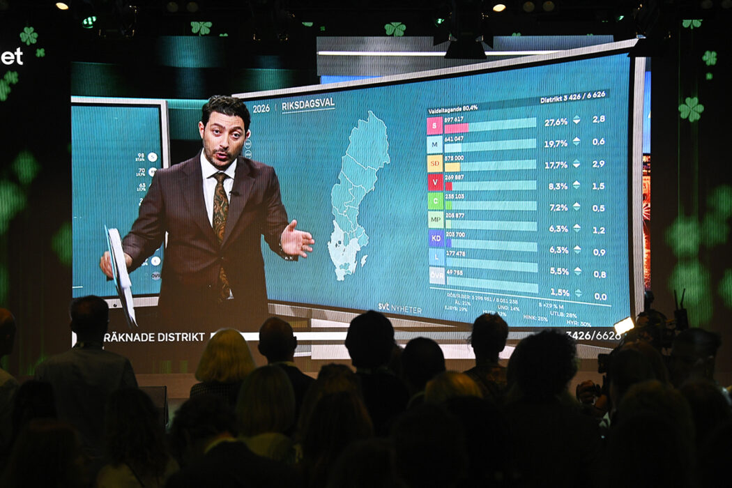 Programledare Fouad Youcefi från SVT:s livesändning visas på storbildsskärm under Centerpartiets valvaka.