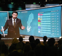 Programledare Fouad Youcefi från SVT:s livesändning visas på storbildsskärm under Centerpartiets valvaka.