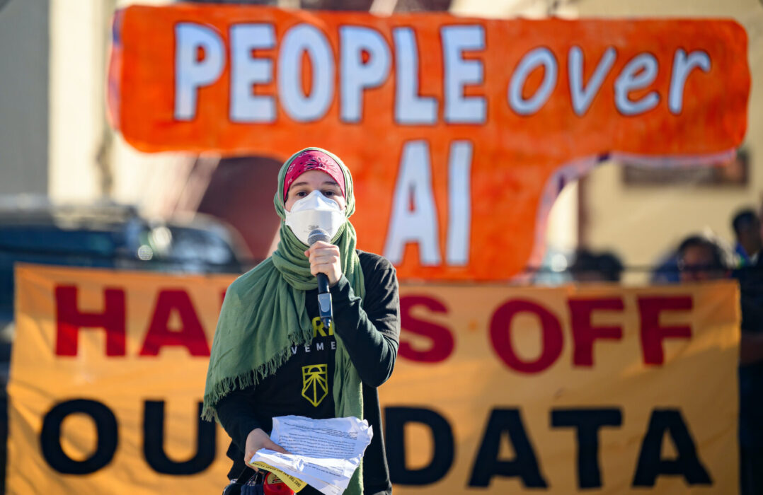 En demonstrant talar utanför en konferens arrangerad av Open AI i San Fransisco.