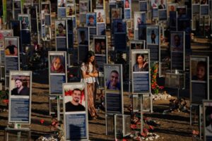 En kvinna går bland uppställda foton av personer som dödades i Hamas attack.